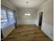 Bright dining room with wood floors, classic wainscoting, and a modern chandelier fixture at 208 Lawrence Rd, Cary, NC 27511