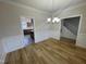 Open dining room featuring wood floors, classic wainscoting, and modern lighting fixture at 208 Lawrence Rd, Cary, NC 27511