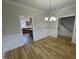 Open dining room featuring wood floors, classic wainscoting, and modern lighting fixture at 208 Lawrence Rd, Cary, NC 27511