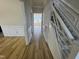 Hallway featuring wood flooring and white wainscoting, leading to the staircase and dining room at 208 Lawrence Rd, Cary, NC 27511