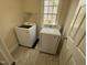 Bright laundry room features modern washer and dryer, window, and vinyl flooring at 208 Lawrence Rd, Cary, NC 27511