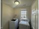 Bright laundry room features modern washer and dryer, window, and wire shelving at 208 Lawrence Rd, Cary, NC 27511