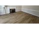 Living room featuring a fireplace with brick hearth, chair railing, and wood flooring at 208 Lawrence Rd, Cary, NC 27511
