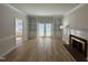 A large, naturally lit living room featuring a fireplace, white trim, and built-in bookshelves with patio access at 208 Lawrence Rd, Cary, NC 27511