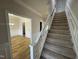 Carpeted staircase with white railing and trim, alongside an open doorway to the dining room at 208 Lawrence Rd, Cary, NC 27511