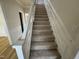 Staircase featuring carpeted steps and white trim, situated next to a doorway to the dining room at 208 Lawrence Rd, Cary, NC 27511