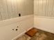 Unfinished basement featuring wood paneling, wainscoting, concrete floor, and plumbing hookups at 2118 N Woodland Rd, Henderson, NC 27536