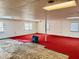 Finished basement with painted white cinder block walls, carpeted floors, and floor restoration equipment at 2118 N Woodland Rd, Henderson, NC 27536