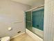 A bathroom featuring blue patterned wallpaper and a blue tiled shower at 2118 N Woodland Rd, Henderson, NC 27536