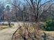 Front yard view showcases mature trees and landscaping enhancing the property's curb appeal at 2118 N Woodland Rd, Henderson, NC 27536