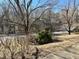 Front yard with mature tree and decorative bushes adds curb appeal to the property at 2118 N Woodland Rd, Henderson, NC 27536