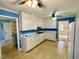 Classic kitchen with white cabinets, appliances, and blue accent walls at 2118 N Woodland Rd, Henderson, NC 27536