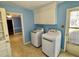 A laundry room with a washer and dryer with blue walls and linoleum floors at 2118 N Woodland Rd, Henderson, NC 27536