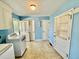 Blue laundry room with washer and dryer hookup plus three doors and a ceiling light fixture at 2118 N Woodland Rd, Henderson, NC 27536