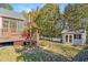 View of a landscaped backyard featuring a deck, pergola, white picket fence, and a shed at 215 Oak Island Ct, Garner, NC 27529