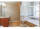 Well-appointed bathroom with a soaking tub, tiled floors, and a cherry wood vanity at 215 Oak Island Ct, Garner, NC 27529