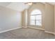Cozy bedroom featuring a vaulted ceiling and a large arched window at 215 Oak Island Ct, Garner, NC 27529