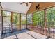 Inviting screened porch featuring wooden floors, ceiling fan, and views of the lush, wooded backyard at 215 Oak Island Ct, Garner, NC 27529