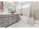 A bright bathroom featuring gray cabinets, a soaking tub, and glass-enclosed shower at 2212 Jollay St, Durham, NC 27703
