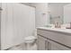 Clean bathroom with a single sink vanity, modern fixtures, and white shower curtain at 2212 Jollay St, Durham, NC 27703