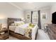 Cozy bedroom with a wooden bed frame, neutral-colored walls, and a window for natural light, alongside a desk and nightstand at 2212 Jollay St, Durham, NC 27703