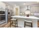 Bright kitchen featuring grey cabinets, stainless steel appliances, and a large island with bar seating and white countertops at 2212 Jollay St, Durham, NC 27703