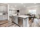 Open concept kitchen and living area with stainless steel appliances and an island, flowing into a well-lit living room at 2212 Jollay St, Durham, NC 27703