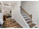 Hallway with a staircase featuring wood and iron railings and views into the dining room at 2212 Jollay St, Durham, NC 27703