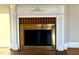 Close-up of fireplace with brick interior, gold screen and decorative white mantel at 2409 Shenandoah Ave, Durham, NC 27704