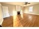 Bright living room featuring hardwood floors, fireplace, large window, and a ceiling fan at 2409 Shenandoah Ave, Durham, NC 27704