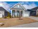 Charming blue home featuring a covered porch with white columns and a well-maintained front yard at 244 Bevis Marks Dr, Fuquay Varina, NC 27526