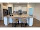 Elegant kitchen island with white cabinets, granite countertops, and seating for two with stainless steel appliances at 244 Bevis Marks Dr, Fuquay Varina, NC 27526
