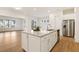 Spacious kitchen with a large island, white cabinets, stainless steel appliances, and hardwood flooring for a modern feel at 244 Bevis Marks Dr, Fuquay Varina, NC 27526