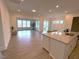 Open kitchen with a large granite island and modern appliances flowing into a spacious living area at 244 Bevis Marks Dr, Fuquay Varina, NC 27526