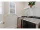 Laundry room with large capacity washer and dryer, wire shelving, and a window at 244 Bevis Marks Dr, Fuquay Varina, NC 27526
