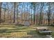 View of the spacious backyard featuring a storage shed, picnic table, and fenced-in yard at 2520 Summit Ln, Creedmoor, NC 27522