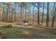 View of the spacious backyard featuring a storage shed, picnic table, and fenced-in yard at 2520 Summit Ln, Creedmoor, NC 27522