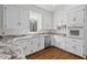 Bright kitchen features white cabinets, stone countertops, stainless steel appliances and hardwood style floors at 2520 Summit Ln, Creedmoor, NC 27522