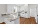 Bright kitchen features white cabinets, stone countertops, stainless steel appliances and hardwood style floors at 2520 Summit Ln, Creedmoor, NC 27522