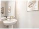 A powder room features a stylish pedestal sink with framed art for a charming touch at 2815 E Brookwood Ct, Creedmoor, NC 27522