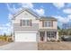 Charming two-story home with a two-car garage and a cozy front porch featuring chairs and a welcoming wreath at 2815 E Brookwood Ct, Creedmoor, NC 27522