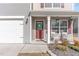 Inviting front porch featuring a wreath-adorned door, cozy chairs, and charming hanging plants at 2815 E Brookwood Ct, Creedmoor, NC 27522