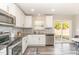 A well-lit kitchen offers stainless steel appliances, granite countertops, and stylish backsplash at 2815 E Brookwood Ct, Creedmoor, NC 27522