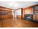 Warm Gathering room features wood paneling, built-in shelving, and cozy fireplace with black accents at 3074 Granville Dr, Raleigh, NC 27609