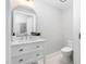 A clean powder room features a white vanity, oval mirror, and ceramic tile floor at 318 Holland Glen St, Fuquay Varina, NC 27526