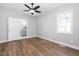 A bright bedroom with hardwood floors, ceiling fan, and large window for natural light at 318 Holland Glen St, Fuquay Varina, NC 27526