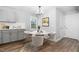 A dining room featuring gray cabinets, a round table with 4 chairs and a modern light fixture at 318 Holland Glen St, Fuquay Varina, NC 27526