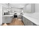 A modern kitchen featuring stainless steel appliances, gray cabinets, white subway tile backsplash, and quartz countertops at 318 Holland Glen St, Fuquay Varina, NC 27526