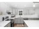 A modern kitchen featuring stainless steel appliances, gray cabinets, white subway tile backsplash, and quartz countertops at 318 Holland Glen St, Fuquay Varina, NC 27526
