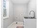 A spacious laundry room with stainless steel sink and tile floor at 318 Holland Glen St, Fuquay Varina, NC 27526